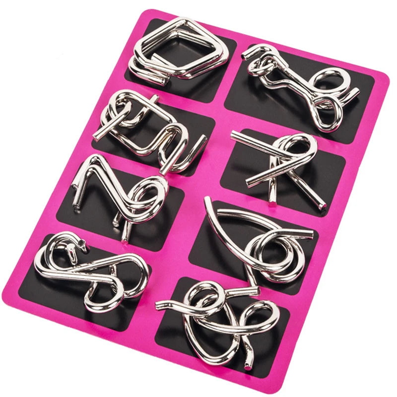 Set of silver metal rings puzzle on a pink and black tray