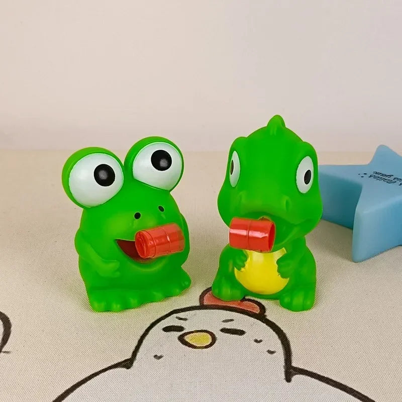 Two green frog-shaped objects with red mouths on a beige surface.