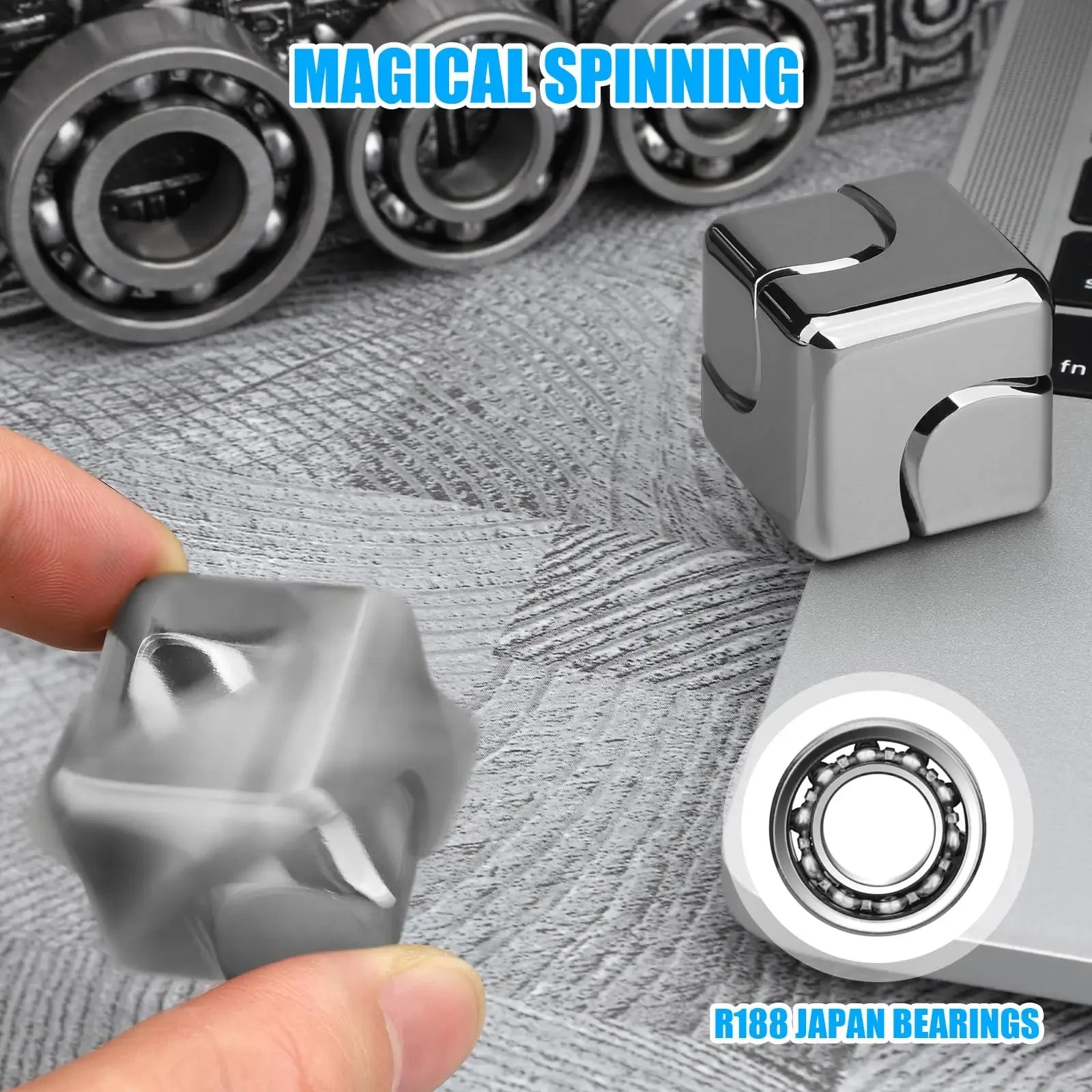 Metallic fidget cube with bearings on a textured surface, featuring 'Magical Spinning' text.